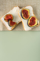 Delicious bruschettas with cream cheese and figs on color background