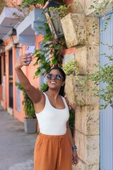 Young woman taking a photo in the streets of Cartagena, Colombia.