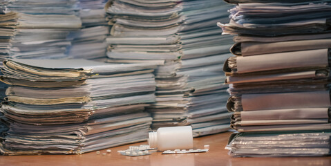 Workplace. Many documents, contracts, legal agreements, papers on work table and soothing pills. Focus on medications on workplace. Stressful about work, fatigue concept. Doping for stressful working