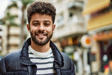 Young arab man smiling outdoor at the town