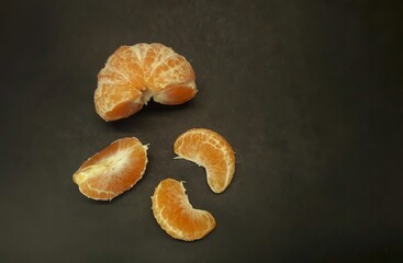 peeled citrus fruits on a black background