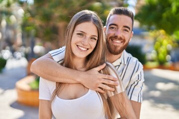 Fototapeta premium Man and woman couple smiling confident hugging each other at park