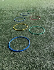 Equipamiento deportivo, anillos planos deportivos de psicomotricidad coloridos sobre campo de césped.