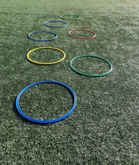 Equipamiento deportivo, anillos planos deportivos de psicomotricidad coloridos sobre campo de...