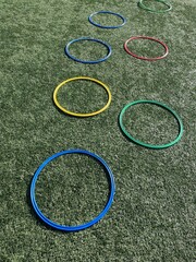 Equipamiento deportivo, anillos planos deportivos de psicomotricidad coloridos sobre campo de césped.