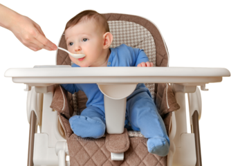 Mother feeding toddler baby from a spoon on a high chair for feeding children, isolated on a white background. Child boy at age of six months eats applesauce while sitting on a baby chair, copy space