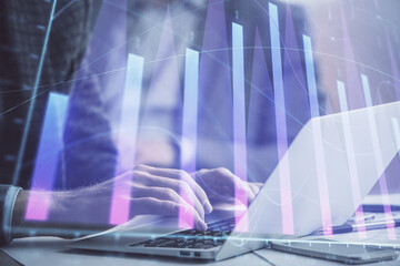 Double exposure of market chart with man working on computer on background. Concept of financial analysis.