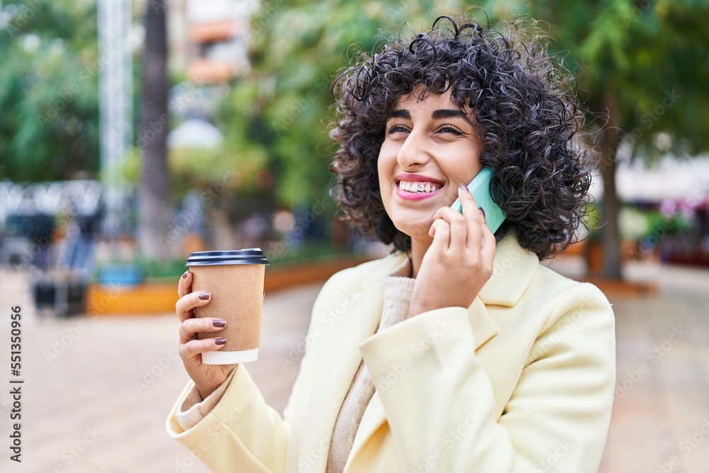 Sticker young middle east woman excutive talking on the smartphone drinking coffee at park