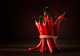 Bunch of red hot chili pepper, close-up, on a dark background, selective focus, no people, concept,...