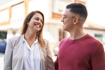 Man and woman mother and son standing together speaking at street