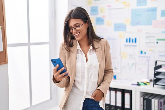 Young beautiful hispanic woman business worker smiling confident using smartphone at office