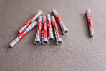 Pile of universal expansion plastic anchors isolated on a gray background. Duo power fasteners for anchoring into various building materials.