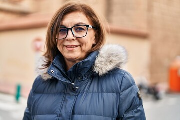 Middle age woman smiling confident wearing glasses at street