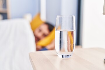 Young hispanic man sleeping on bed at bedroom