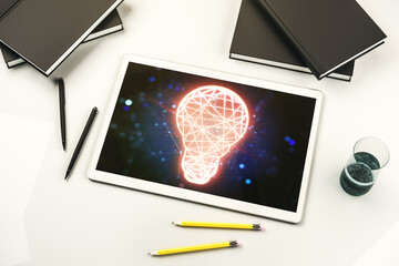 Modern digital tablet monitor with creative light bulb hologram, research and development concept. Top view. 3D Rendering