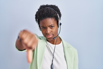 African american woman wearing call center agent headset looking unhappy and angry showing...