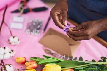 Obraz na płótnie Canvas African american woman florist preparing envelope letter at flower shop