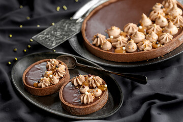 tarte au chocolat et caramel sur une nappe noire