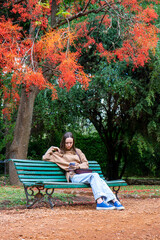 Fototapeta premium a young girl in the park sitting under a tree