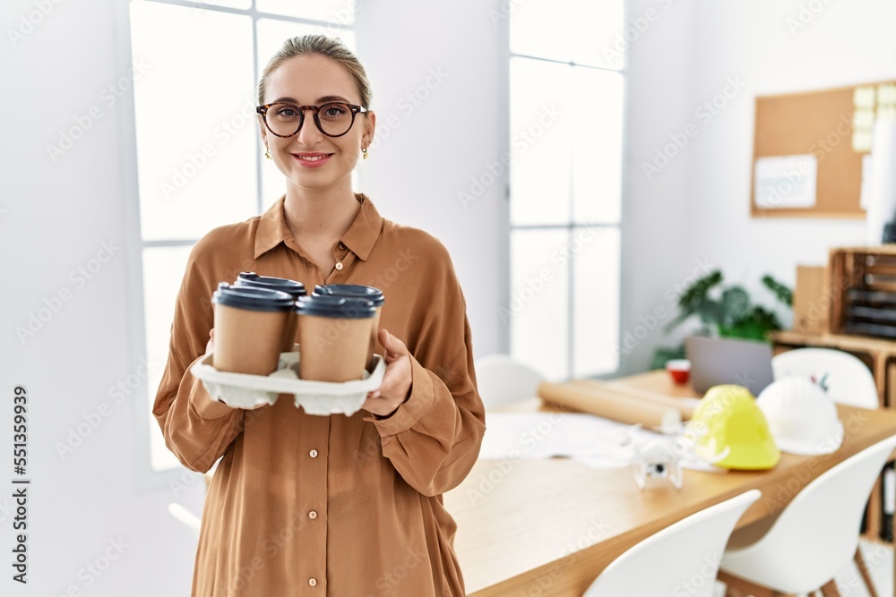 Wall mural young blonde woman smiling confident holding take away coffee at architect studio