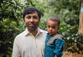 South asian young father holding his little son 