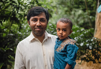 South asian young father holding his little son 