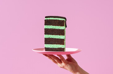 Layered cake slice on a plate, minimalist on a purple background.