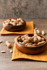 Image of bunch of peanuts in a bowl on a wooden table