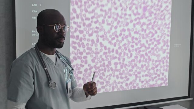 Young adult African American general practitioner making presentation about bacterial or infectious disease at medical conference