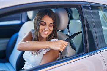 Young beautiful hispanic woman smiling confident wearing car belt at street