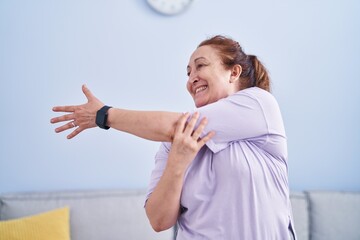 Senior woman smiling confident stretching arms at home