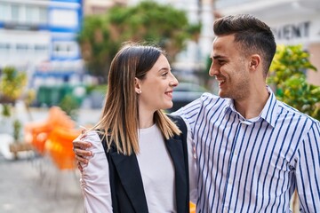 Man and woman couple smiling confident hugging each other at street