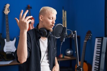Young caucasian man artist singing song at music studio