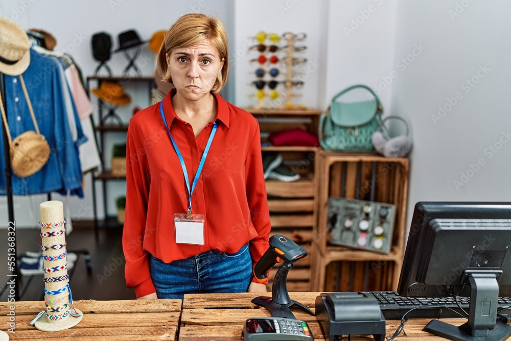 Wall mural Middle age blonde woman working working as manager at retail boutique depressed and worry for distress, crying angry and afraid. sad expression.