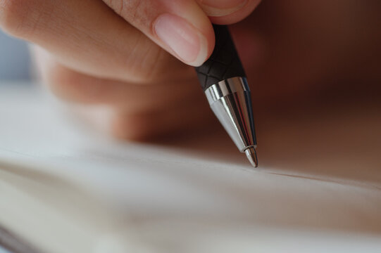 Female hand close-up writes with a pen in a blank notebook.she writing a daily lifetime.Business woman, worker,writer, personal blog Concepts.
