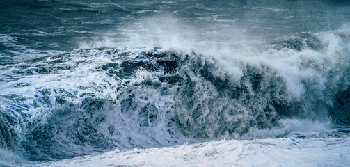 Dark blue dramatic sea storm. Ocean water bubbling near coast shore with lot of foam. - Powered by Adobe