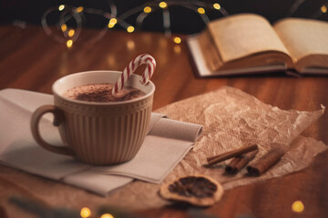 A mug of hot cocoa on a wooden table. Cozy Christmas composition. Decorations in a retro style. The feeling of a holiday. The concept of coziness, good mood and winter holidays.