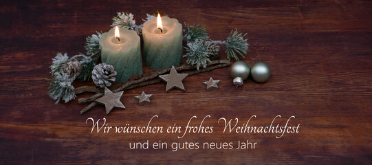 Weihnachtskarte: Grüne Kerzen mit Weihnachtsschmuck auf altem Holz und dem Text wir wünschen ein...