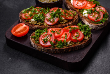 Tasty bruschetta with tomatoes, mozzarella, basil, spices and herbs