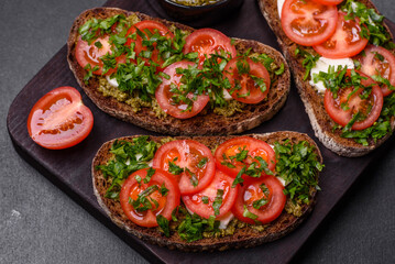 Tasty bruschetta with tomatoes, mozzarella, basil, spices and herbs