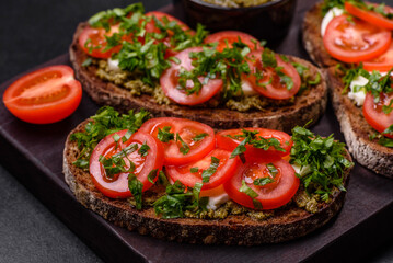 Tasty bruschetta with tomatoes, mozzarella, basil, spices and herbs