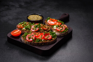 Tasty bruschetta with tomatoes, mozzarella, basil, spices and herbs