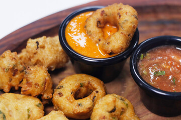 traditional indian snack food, crispy deep fried vada and chutneys in a serving plate