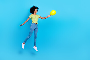 Full body length photo of excited positive dreaming teenager lady hold air balloon levitate look empty space her present isolated on blue color background