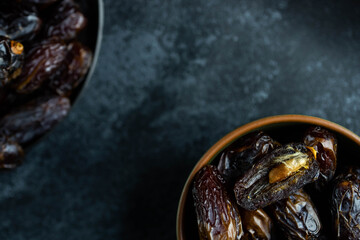 Dates fruit in bowl on dark background. Dried organic Superfood.