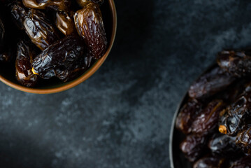 Dates fruit in bowl on dark background. Dried organic Superfood.
