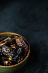 Dates fruit in bowl on dark background. Dried organic Superfood.