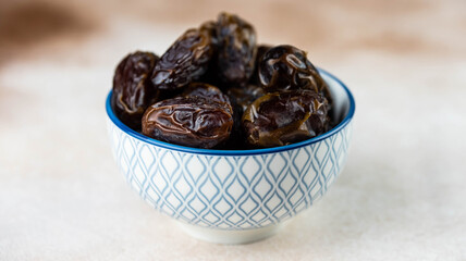 Dates fruit in bowl on white background. Dried organic Superfood.
