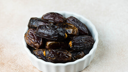 Dates fruit in bowl on white background. Dried organic Superfood.