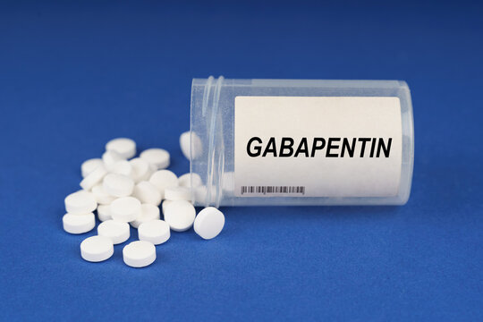 On a blue surface are pills and a dusty jar with the inscription - Gabapentin